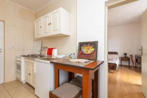 eine Küche mit weißen Schränken und einer Arbeitsplatte in der Unterkunft Sole Solei apartman 2 - Meljine in Meljine