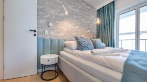 a bedroom with a large bed and a window at Plażowa Park, Sun & Snow in Międzywodzie