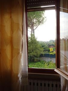 una ventana abierta con vistas al jardín en Dolci Sogni, en Pisa