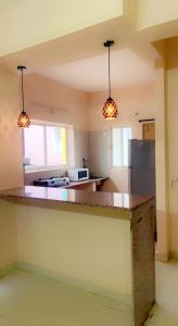 a kitchen with a counter and two pendant lights at TheReefApartment in Hyderabad