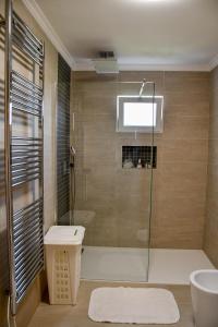 uma casa de banho com um chuveiro, um WC e um lavatório. em Casa do Cantinho do Muro em São Vicente