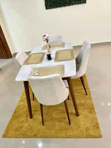 a white table with two chairs and a vase with flowers at TheReefApartment in Hyderabad