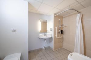 La salle de bains est pourvue d'un lavabo, de toilettes et d'une douche. dans l'établissement B&B HOTEL Saintes, à Saintes