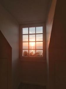 een raam in een kamer met zonsondergang bij Magnifique cocon vue mer in Trouville-sur-Mer