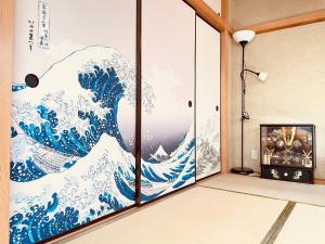 a room with a mural of a wave at 302东京中心全新装修宽敞明亮的公寓 3分钟步行路程到门前仲町站 两条地铁线直达东京上野新宿 in Tokyo