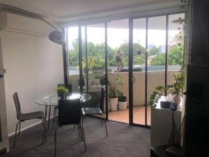 Habitación con mesa, sillas y balcón. en SOUTH BRISBANE APARTMENTS Free Parking, en Brisbane
