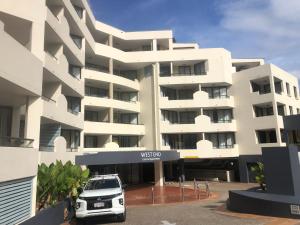 a white building with a car parked in front of it at SOUTH BRISBANE APARTMENTS Free Parking in Brisbane