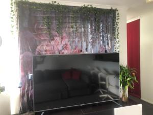 una sala de estar con una gran TV de plasma. en SOUTH BRISBANE APARTMENTS Free Parking, en Brisbane