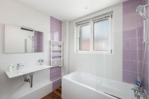 un bagno con vasca, lavandino e specchio di Une belle vue de Brest/T2 lumineux /Centre-Ville a Brest