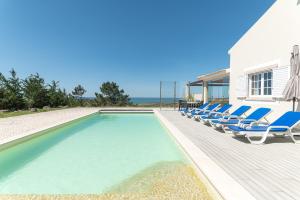 una piscina con sedie a sdraio accanto a una casa di Villa Terra Mar a Ericeira