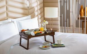 a tray of food and drinks on a bed at The Ritz-Carlton, Baku in Baku