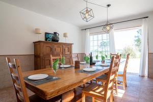 una sala da pranzo con tavolo e sedie in legno di Villa Terra Mar a Ericeira