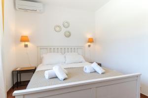 una camera da letto con un letto con due cuscini sopra di Villa Terra Mar a Ericeira Altre 34 foto