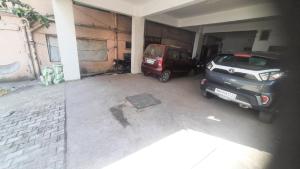 a garage with two cars parked in it at Elite Inn, Kolhapur, 100 Mts from Railway Station in Kolhapur