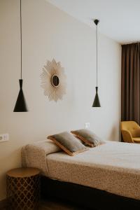 1 dormitorio con cama y espejo en la pared en Apartamentos Levante - Mares, en Torre del Mar