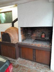uma cozinha com um forno de tijolos numa garagem em I Casa de invitados cerquita de la playa buenas olas em La Aguada