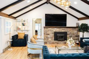 a living room with blue furniture and a stone fireplace at Cowry Acres - The First House Villa w Hot Tub in New Hope