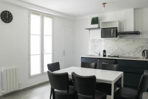- une cuisine avec une table et des chaises dans la chambre dans l'établissement Charming house with an outdoor terrace, à Ivry-sur-Seine