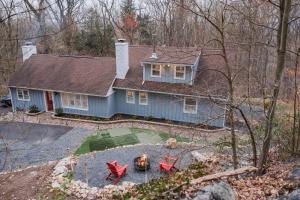 a blue house with red chairs in front of it at Cowry Acres - 11 Acre Enchanted Retreat, Hot Tub in New Hope