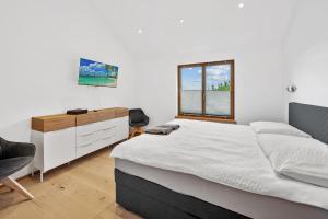 a bedroom with a bed and a dresser and a window at Luxus Chalet Max in Glanz an der Weinstraße 