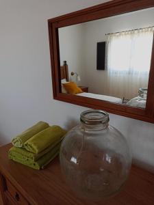 einem großen Glasgefäß auf einem Holztisch vor einem Spiegel in der Unterkunft La Barrica in Soo