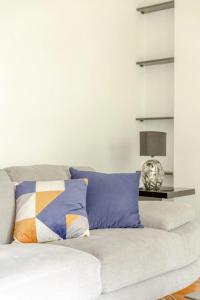 a white couch with colorful pillows in a living room at Bright & Cosy 2BD by the Canal! - Limehouse in London