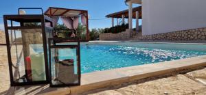 a swimming pool in front of a house at Holiday House DA & DO in Pakoštane