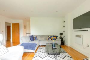 a living room with a white couch and a tv at Bright & Cosy 2BD by the Canal! - Limehouse in London