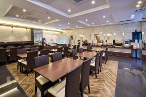 a restaurant with wooden tables and chairs and a counter at Hotel WBF Namba Motomachi in Osaka