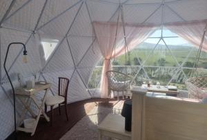 a room with a large window with chairs and a table at Pom Gratz - EcoDomes in Hartebeest Rivier