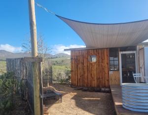 a wooden cabin with a view of the mountains at Pom Gratz - EcoDomes in Hartebeest Rivier