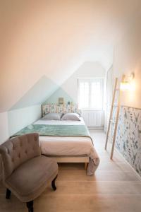 1 dormitorio con 1 cama y 1 silla en La Longère Gasiaquoise, en Gauchy