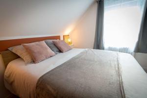1 dormitorio con 1 cama grande y ventana en La Longère Gasiaquoise, en Gauchy