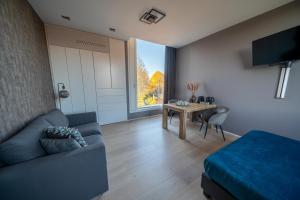a living room with a couch and a table at Bed & Wellness Boxtel, 4 persoonskamer met eigen badkamer in Boxtel +1 photo