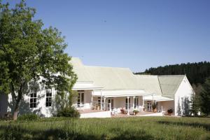 a white house with a gambrel roof at Rozendal Stay in Stellenbosch