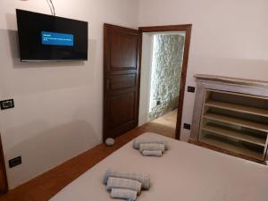 um quarto com uma cama com duas almofadas e uma televisão em Caolzio18 em CastellʼArquato
