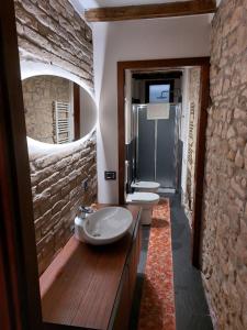 baño con 2 lavabos y pared de piedra en Caolzio18 en CastellʼArquato