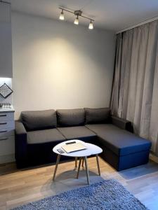 een woonkamer met een bank en een tafel bij Moderni yksiö huippu sijainnilla in Jyväskylä