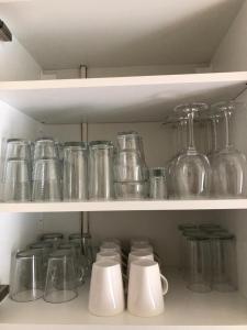 a shelf filled with glass jars and other items at Comfortabel 6-persoons huisje nabij strand, bos, duinen en stad in Warmenhuizen