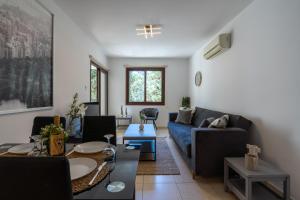 - un salon avec un canapé bleu et une table dans l'établissement Mia 1-Bedroom Apartment in Larnaca, à Larnaka
