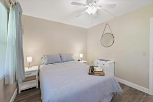 a white bedroom with a bed and a ceiling fan at Quaint condo steps to the beach and dining in Marco Island +17 photos