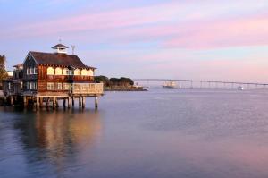 een huis op een dok in het water met een brug bij San Diego Marriott Marquis and Marina in San Diego