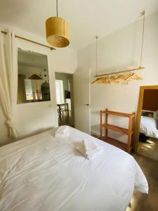 een wit bed in een slaapkamer met een spiegel bij Piso San Eloy - Centro de Cordoba in Córdoba
