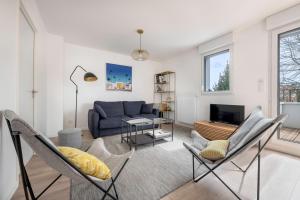 een woonkamer met een blauwe bank en stoelen bij Appartement moderne pour 4 a La Baule in La Baule