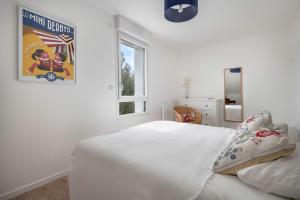a white bedroom with a bed and a window at Appartement moderne pour 4 a La Baule in La Baule