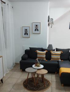 a living room with a black couch and a table at La bella casa thassos in Limenas