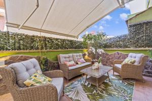 d'une terrasse avec des chaises en osier et une table. dans l'établissement Ca' Alessandra, à Carloforte