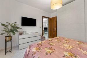a bedroom with a bed and a tv on a wall at Ca' Alessandra in Carloforte