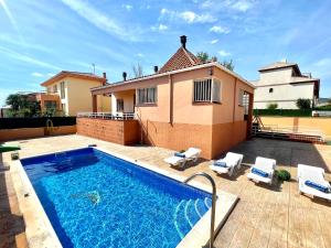 una piscina di fronte a una casa di Arenda Clara villa con piscina privada al lado de la playa a Hospitalet de l'Infant