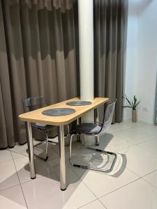 a wooden table with chairs in a room with curtains at Apartmani Queen in Kraljevo